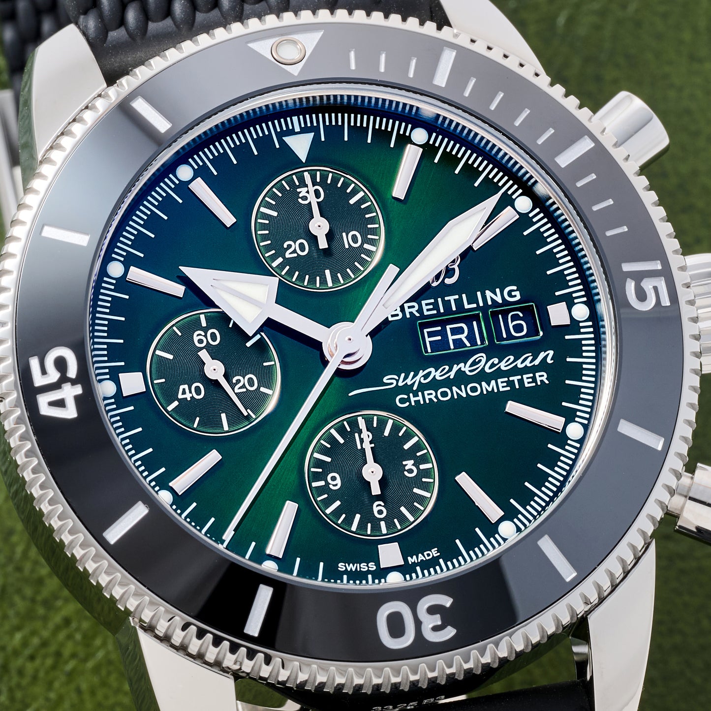 Close-up of the Breitling SuperOcean Heritage Chronograph 44, featuring a green and blue dial with three subdials, day-date display, silver hour markers, and a black rotating bezel.