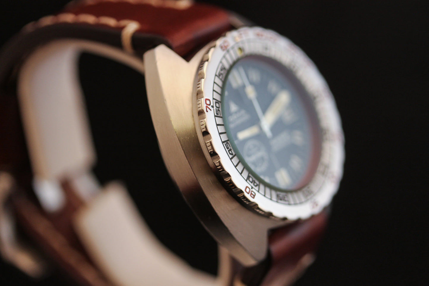 Close-up of the DOXA Sub 300T Sharkhunter Aqua Lung dive watch, featuring a brown leather strap, numbered silver bezel, and dark round face—an iconic DOXA diver’s style—set against a black background.