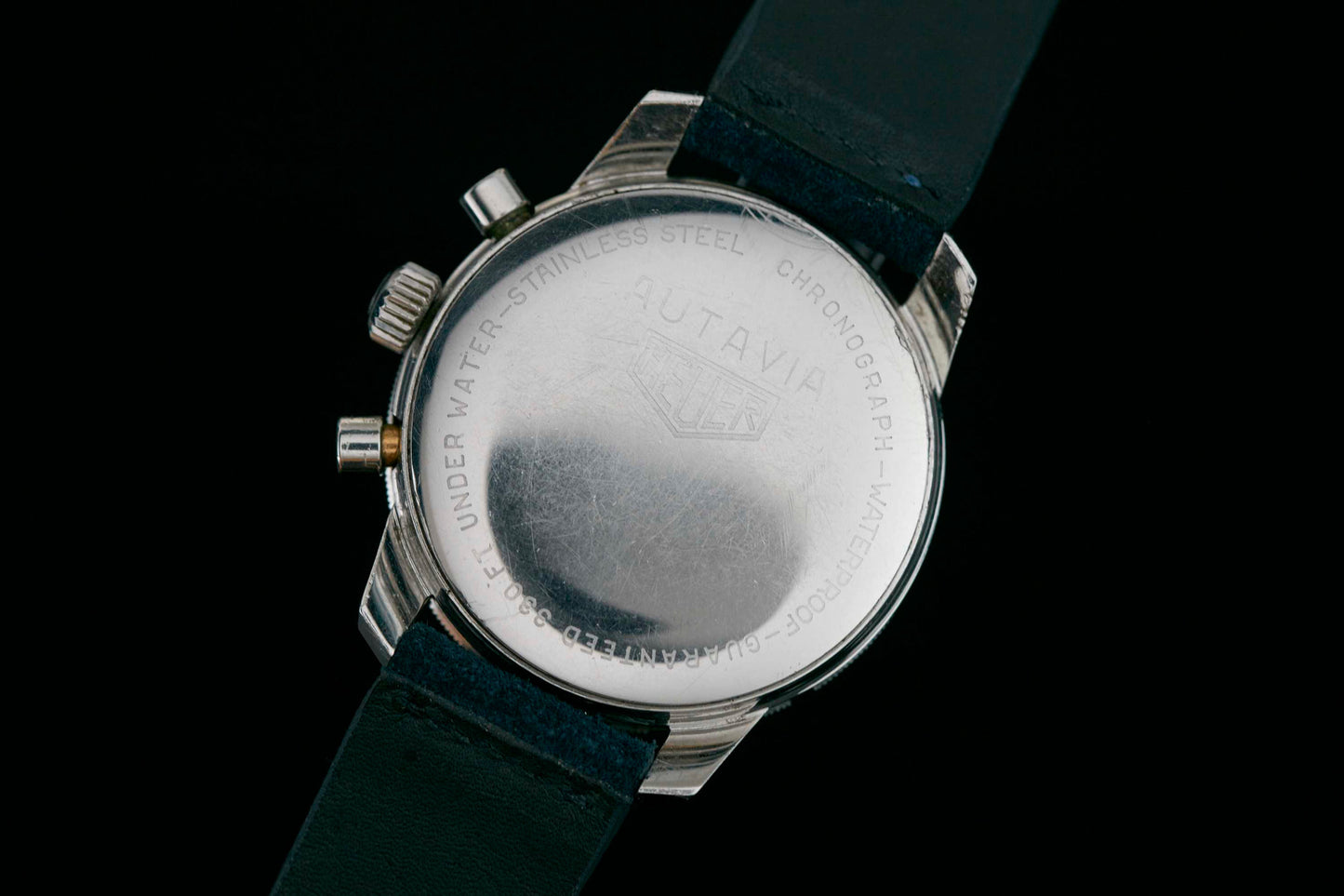 The Heuer Skipper Reference 7764 features a stainless steel case back engraved with AUTAVIA, CHRONOGRAPH, WATERPROOF, and STAINLESS STEEL plus the Heuer logo. It comes with a black leather strap and two side buttons. Detailed Description Coming Soon!.