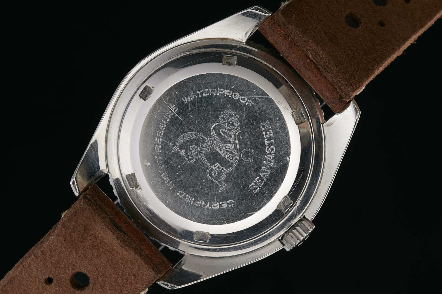 The back of the Omega Seamaster 300 by Omega features engraved text: Waterproof, Seamaster, and Certified High Pressure on its stainless steel case with brown leather straps. Detailed description coming soon!.
