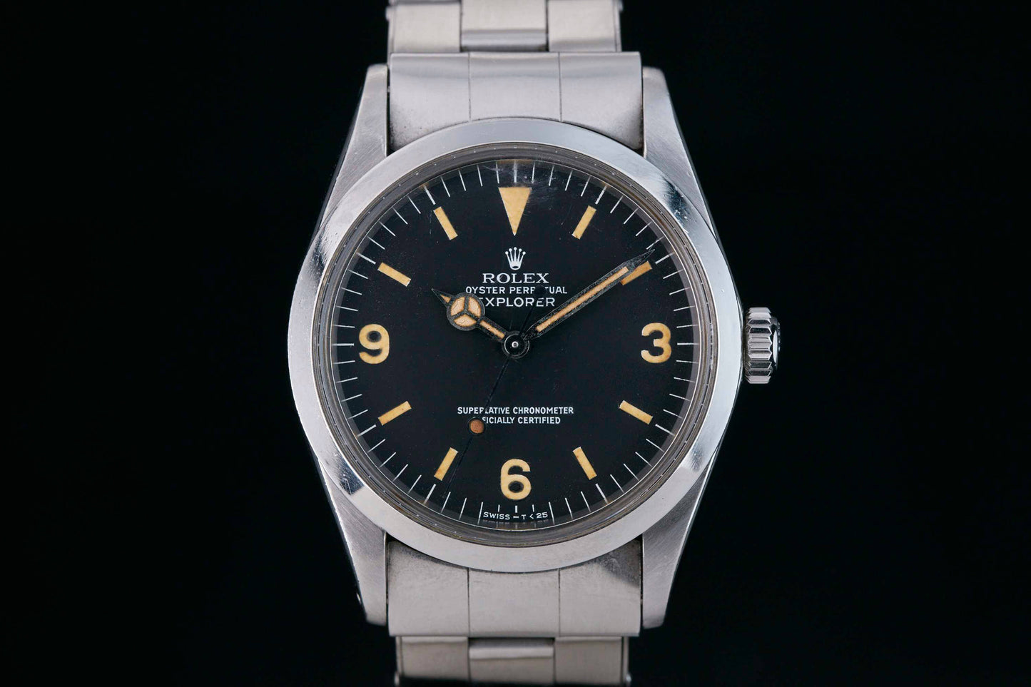 The Rolex Explorer by Rolex features a 3-6-9 black Arabic dial, a silver case and bracelet, and yellowed hands and markers for a vintage Everest-inspired look.