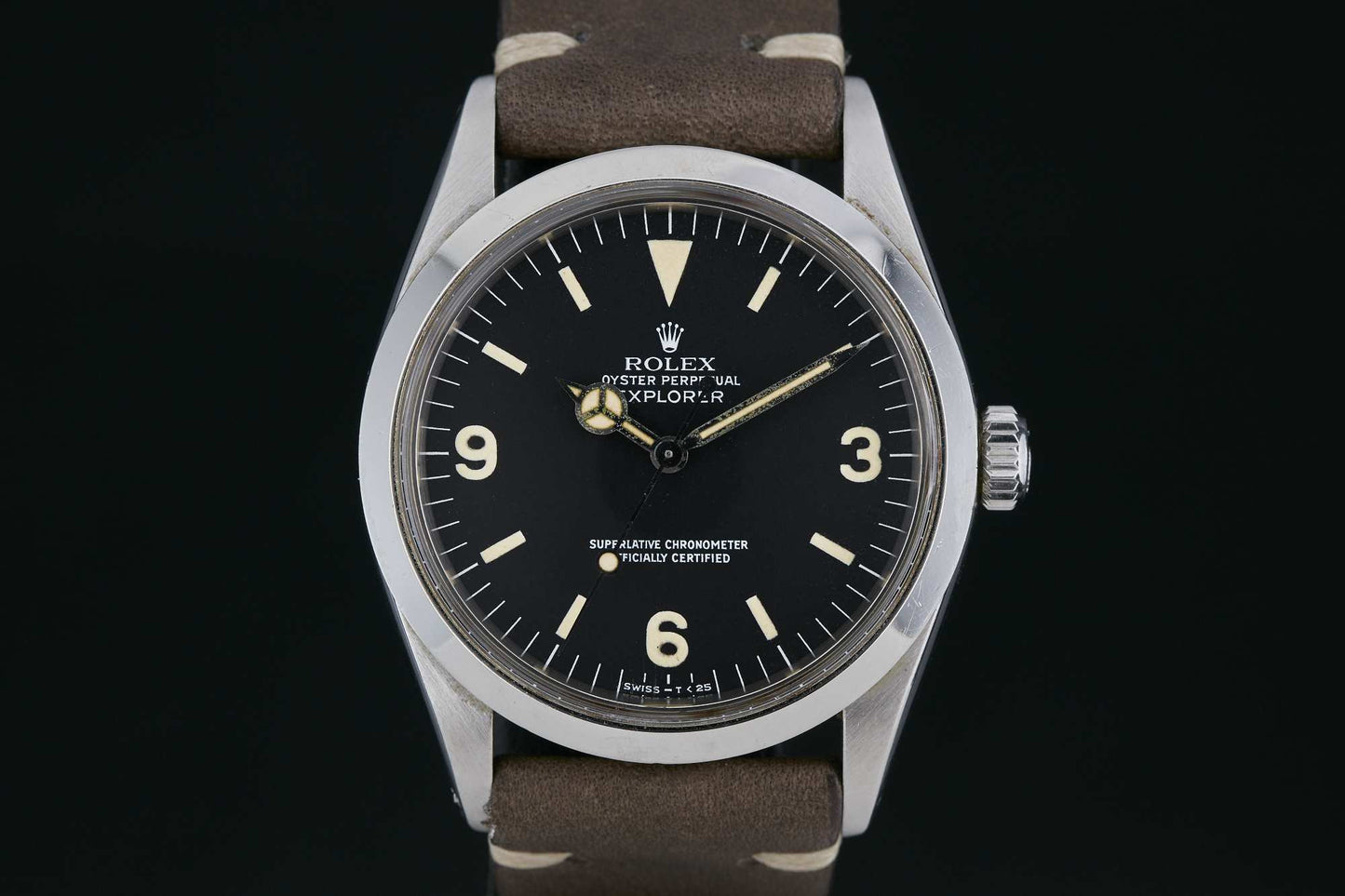 A close-up of a Rolex Explorer 1016 by Rolex featuring a black dial, luminous hour markers, Arabic numerals at 3, 6, and 9, and a brown leather strap. Detailed description coming soon!.