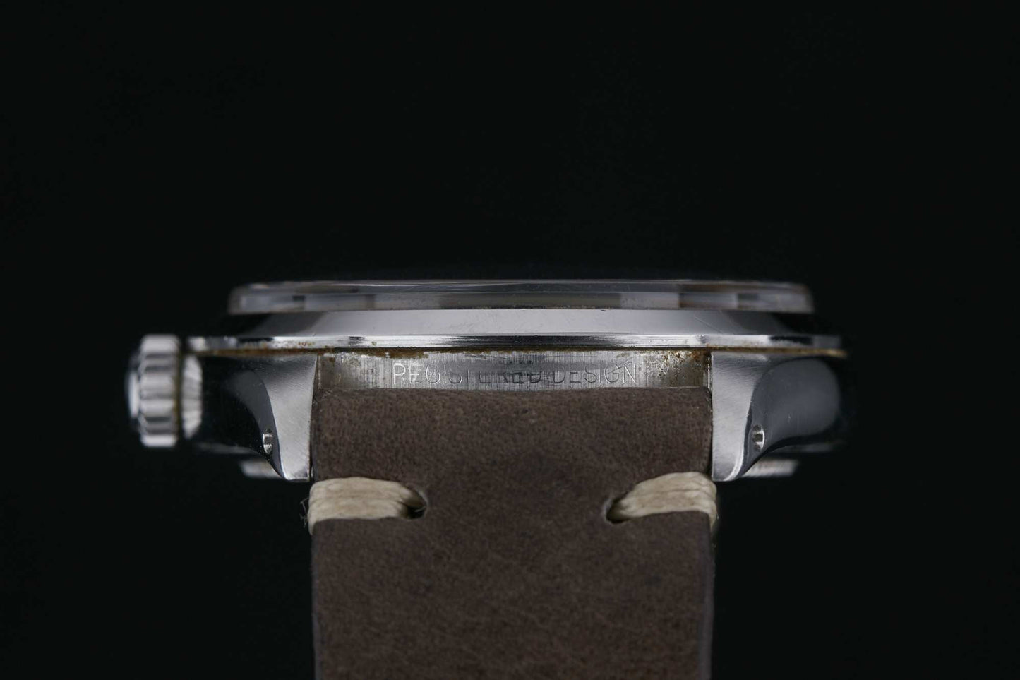 Side view of the Rolex Explorer 1016 wristwatch by Rolex, featuring a round silver case, left-side crown, and brown leather strap with white stitching, set against a black background. Detailed description coming soon!.