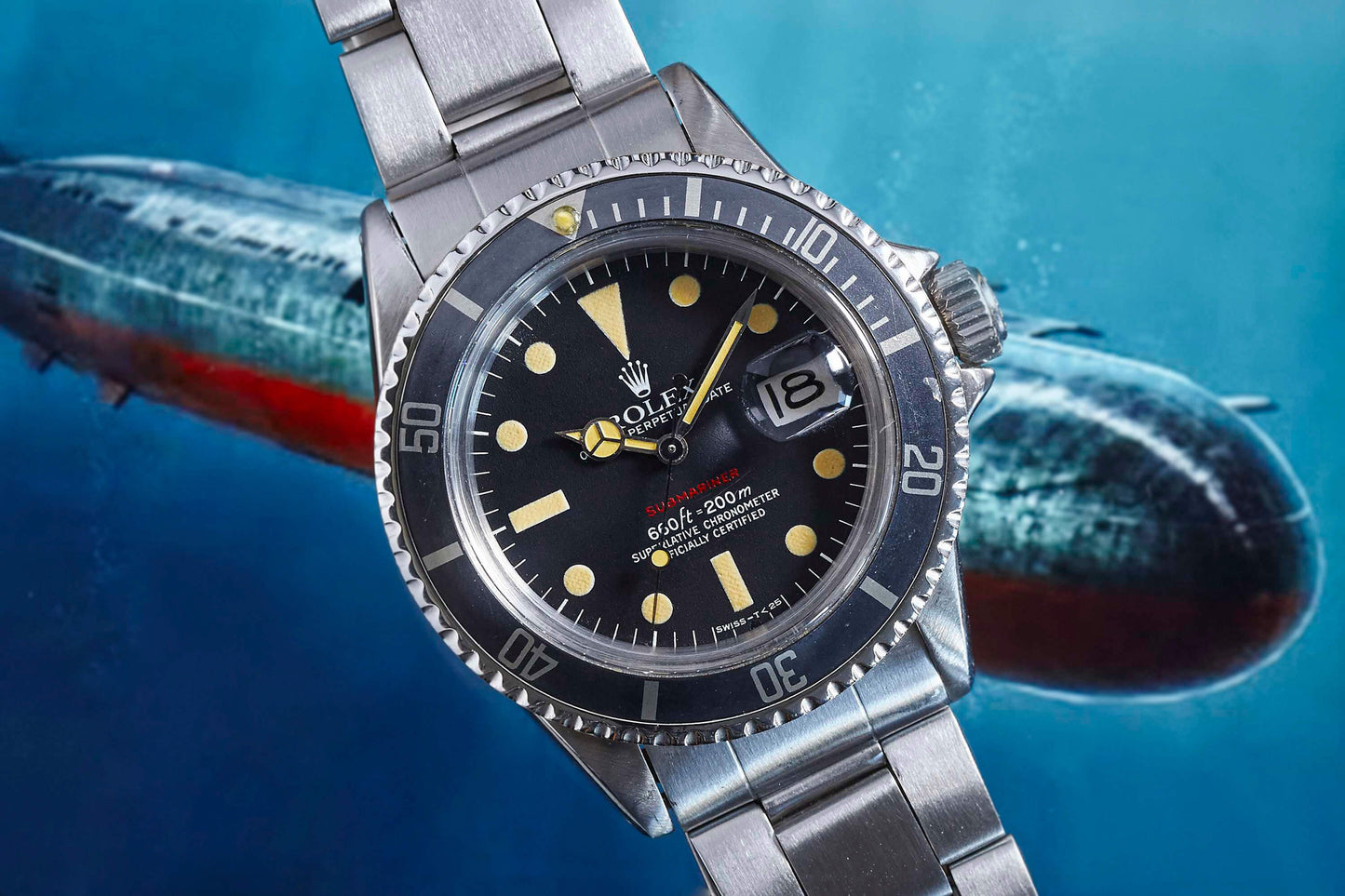 A close-up of the Rolex Submariner dive watch by Rolex with a metal band is angled on a blue background featuring a blurred submarine, highlighting its date display, prominent hour markers, and hands.