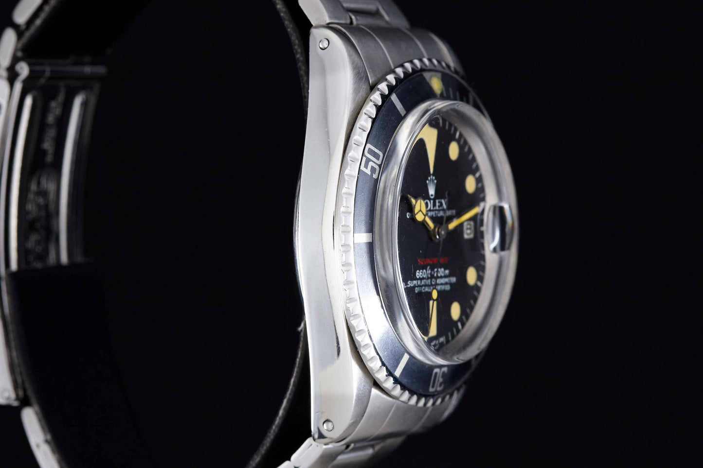 A close-up side view of the Rolex Submariner by Rolex, featuring a silver stainless steel band, black bezel and dial, yellow hour markers, set against a black background.