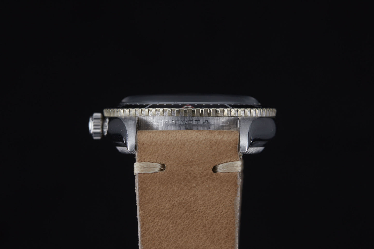 Side view of the Rolex Turn-O-Graph by Rolex featuring a metal case, prominent rotating bezel, and tan leather strap, set against a plain black background reminiscent of classic sports models.