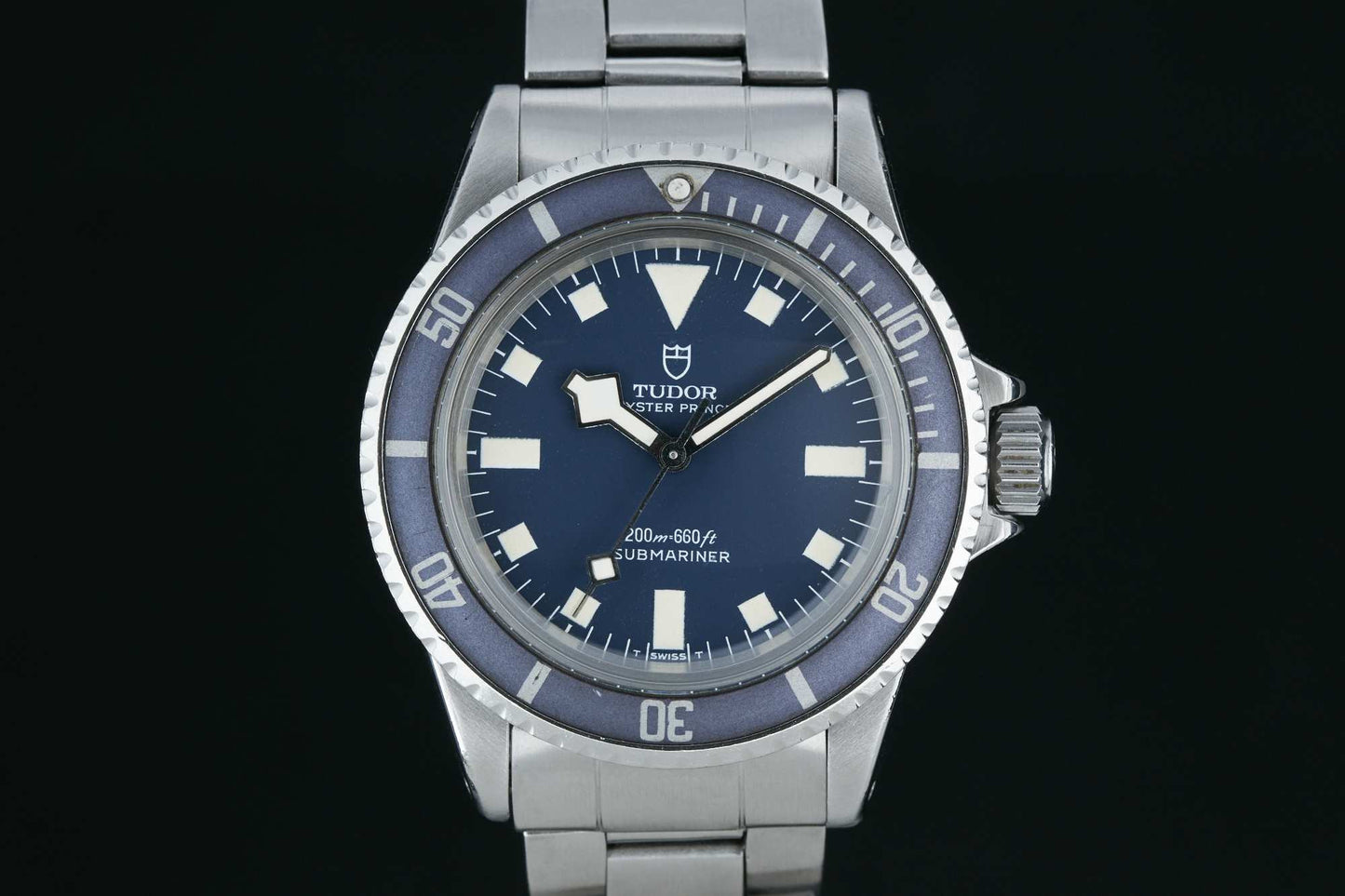 A close-up of the Tudor Submariner Snowflake by Tudor, featuring a blue dial, white hour markers, rotating bezel, and stainless steel bracelet. The watch displays the time as 10:14. Detailed description coming soon!.
