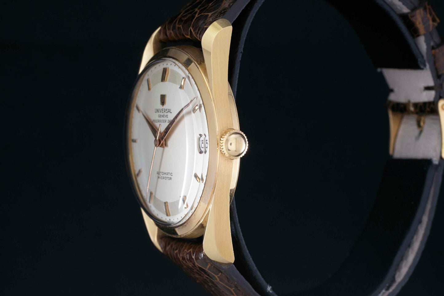 A close-up side view of a Universal Genève Polerouter Date shows its gold case, white dial, brown leather strap, and visible crown. The watch face displays Universal Genève and Automatic Microtor, making it a standout vintage piece.