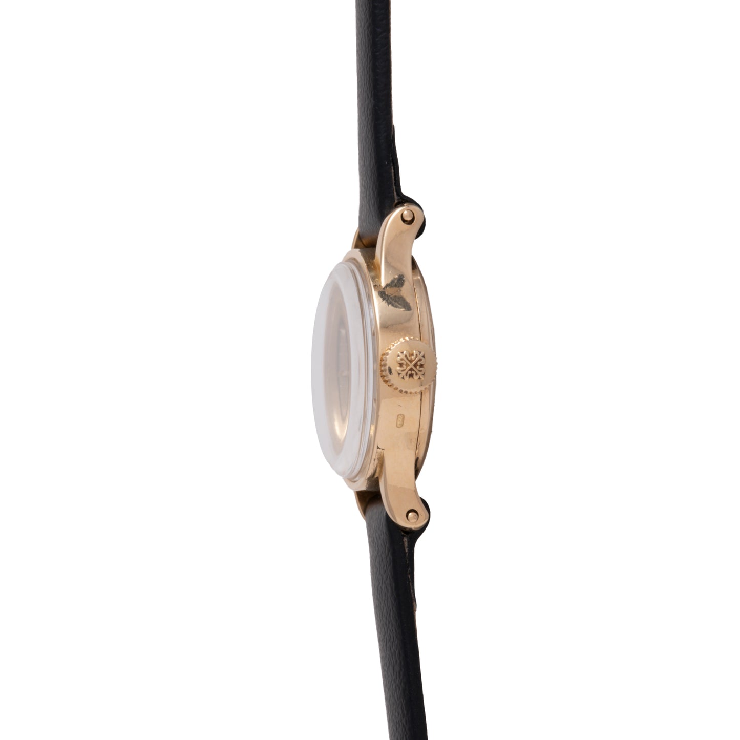 A side view of the Patek Philippe Calatrava 'Tiffany & Co' ladies dress watch, featuring an 18K yellow gold case, textured crown, and black leather strap. The watch face is not visible from this angle.