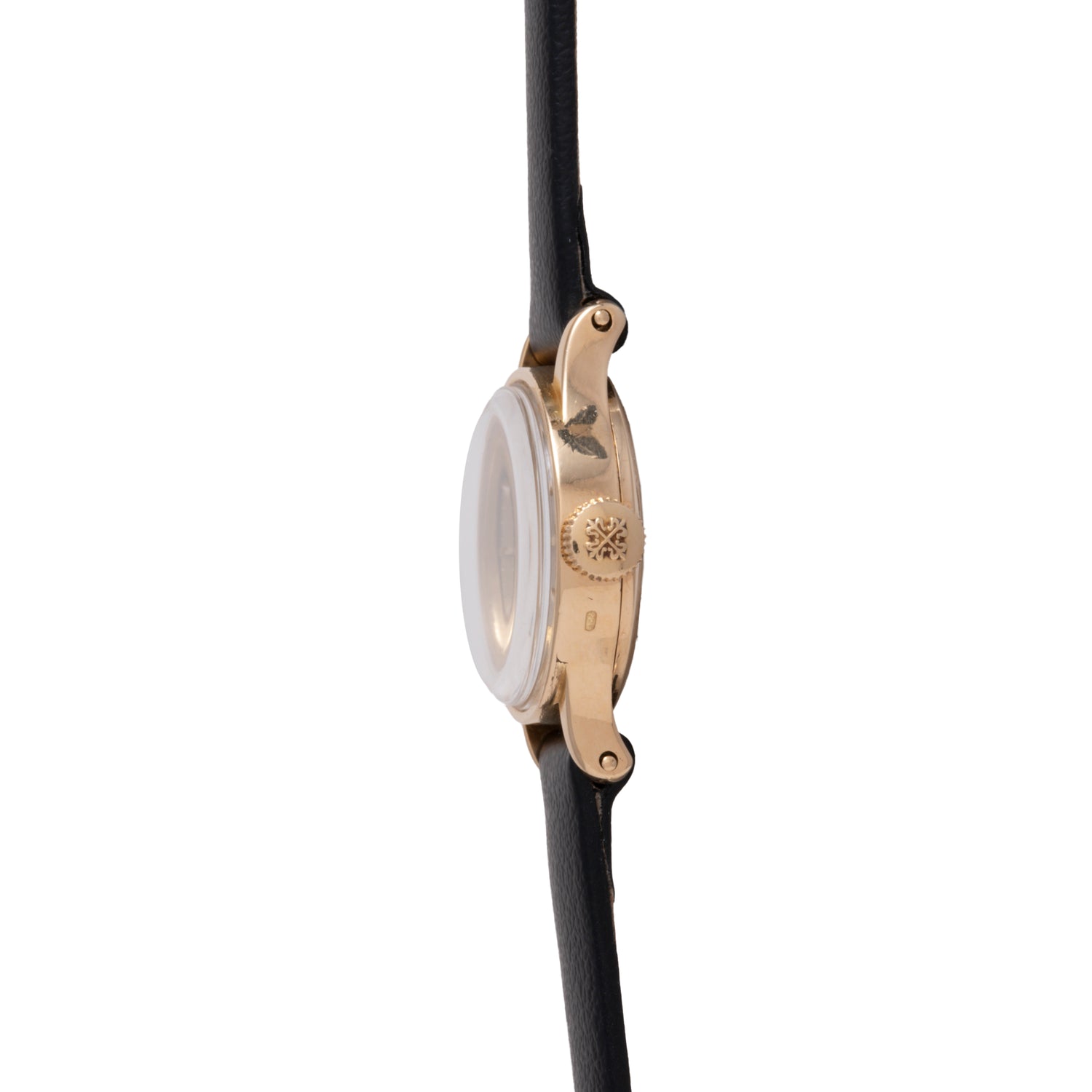 A side view of the Patek Philippe Calatrava 'Tiffany & Co' ladies dress watch, featuring an 18K yellow gold case, textured crown, and black leather strap. The watch face is not visible from this angle.