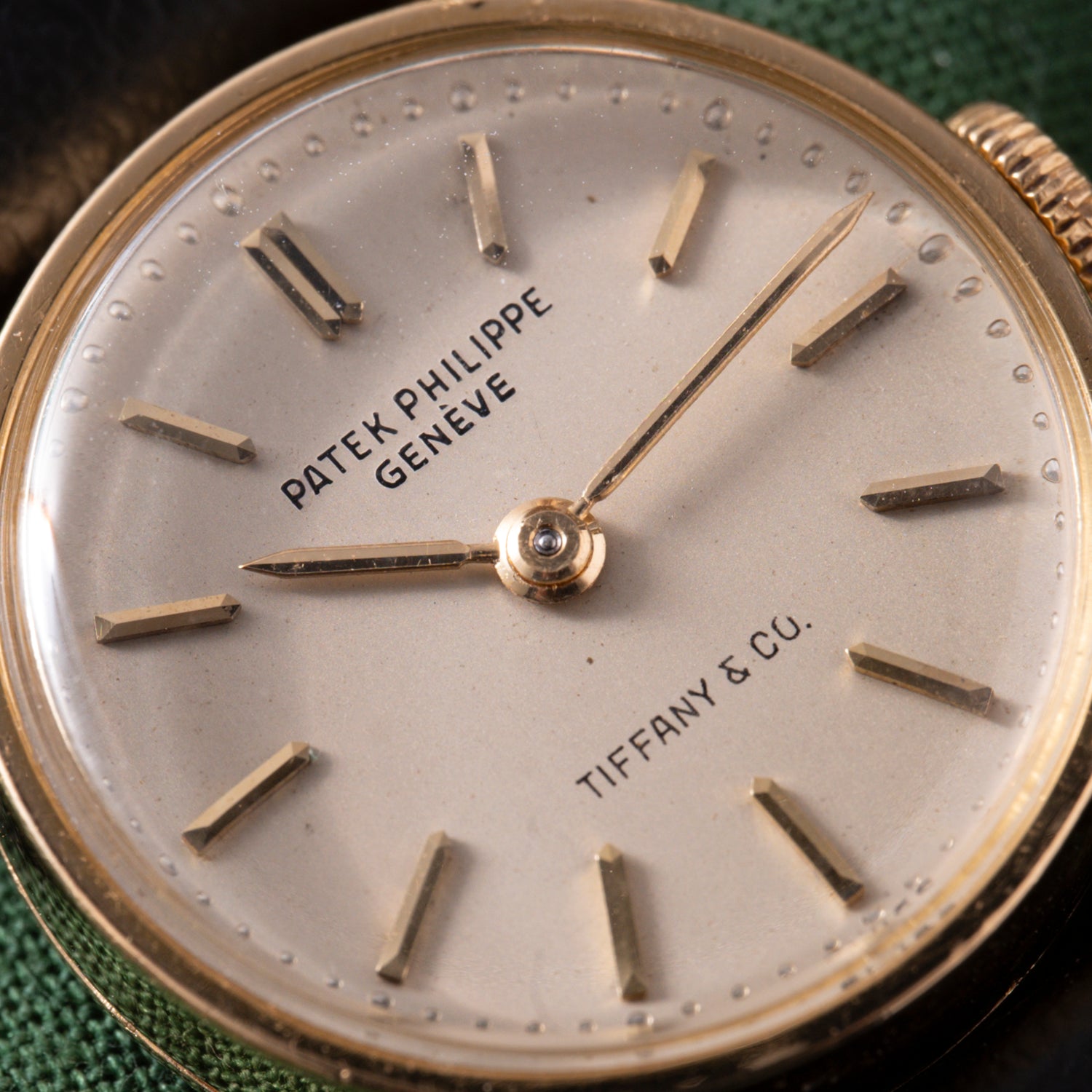 Close-up of a vintage Patek Philippe Calatrava 'Tiffany & Co' ladies dress watch with gold hour markers and hands, TIFFANY & CO. and PATEK PHILIPPE GENÈVE on a cream dial, set in 18K yellow gold.