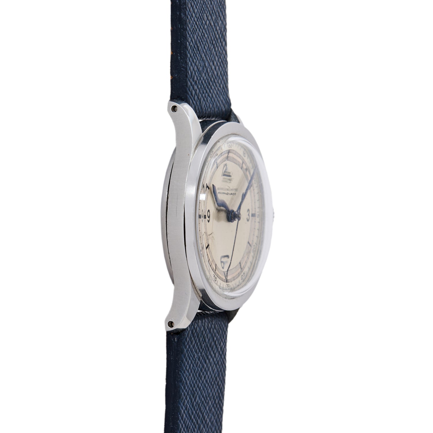 A side view of the Movado 'Calatrava' Steel shows its silver case, cream dial, and navy blue textured strap with dark hour markers and hands, displayed against a white background.