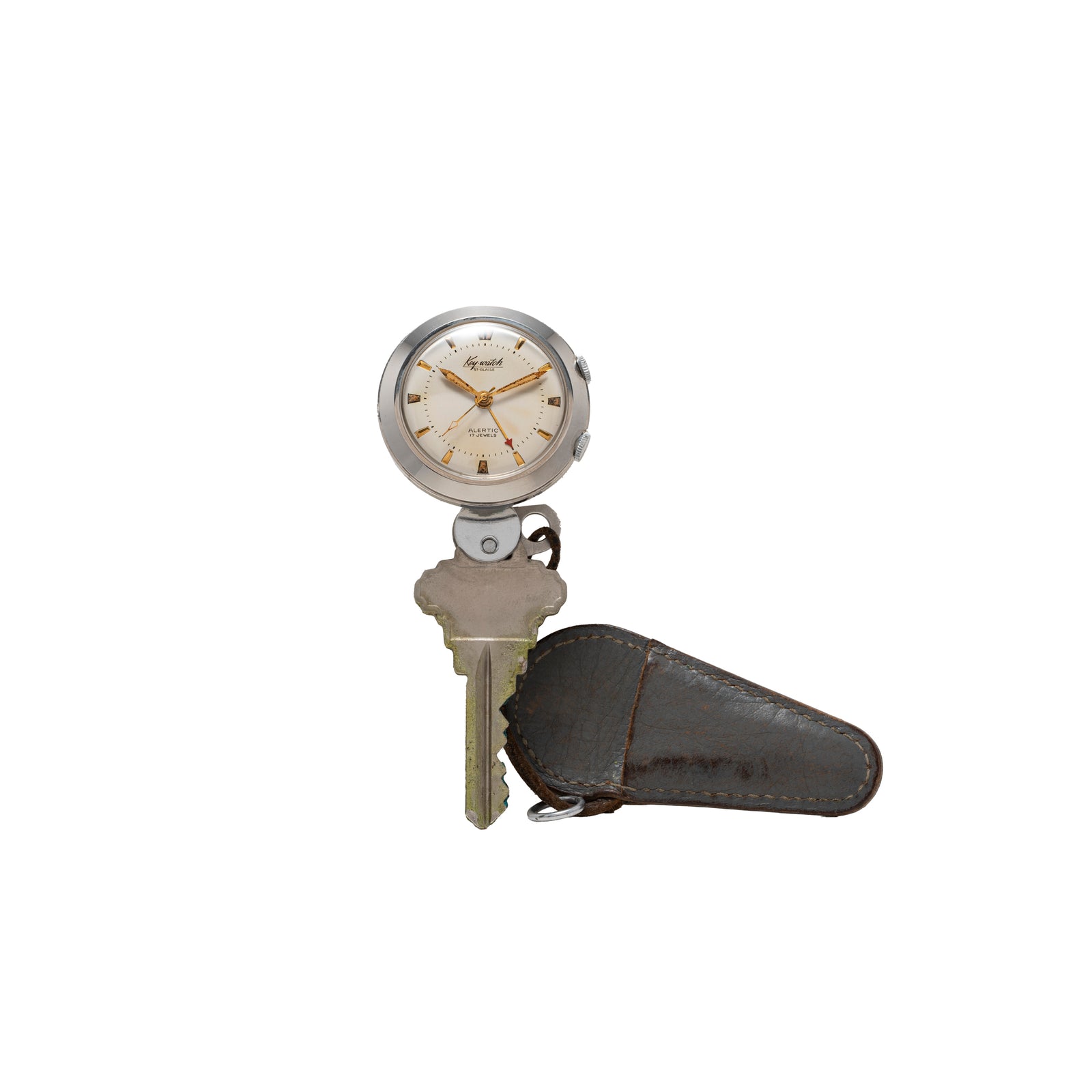 The Saint Blaise Key Watch Alarm by Saint Blaise features a metal key with a round vintage watch alarm on top and a brown leather cover on the blade, ideal for classic car enthusiasts, displayed against a white background.