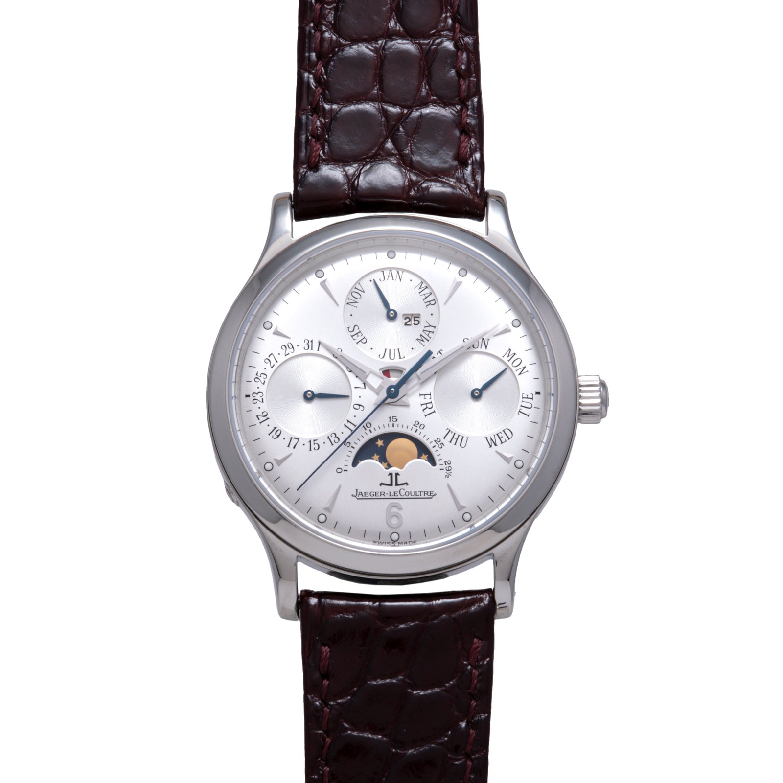 The Jaeger LeCoultre Master Control Perpetual Calendar is a silver wristwatch featuring a brown leather strap, silver dial with blue hands, vintage style, calendar subdials (day, date, month), and a moon phase at 6 o’clock.
