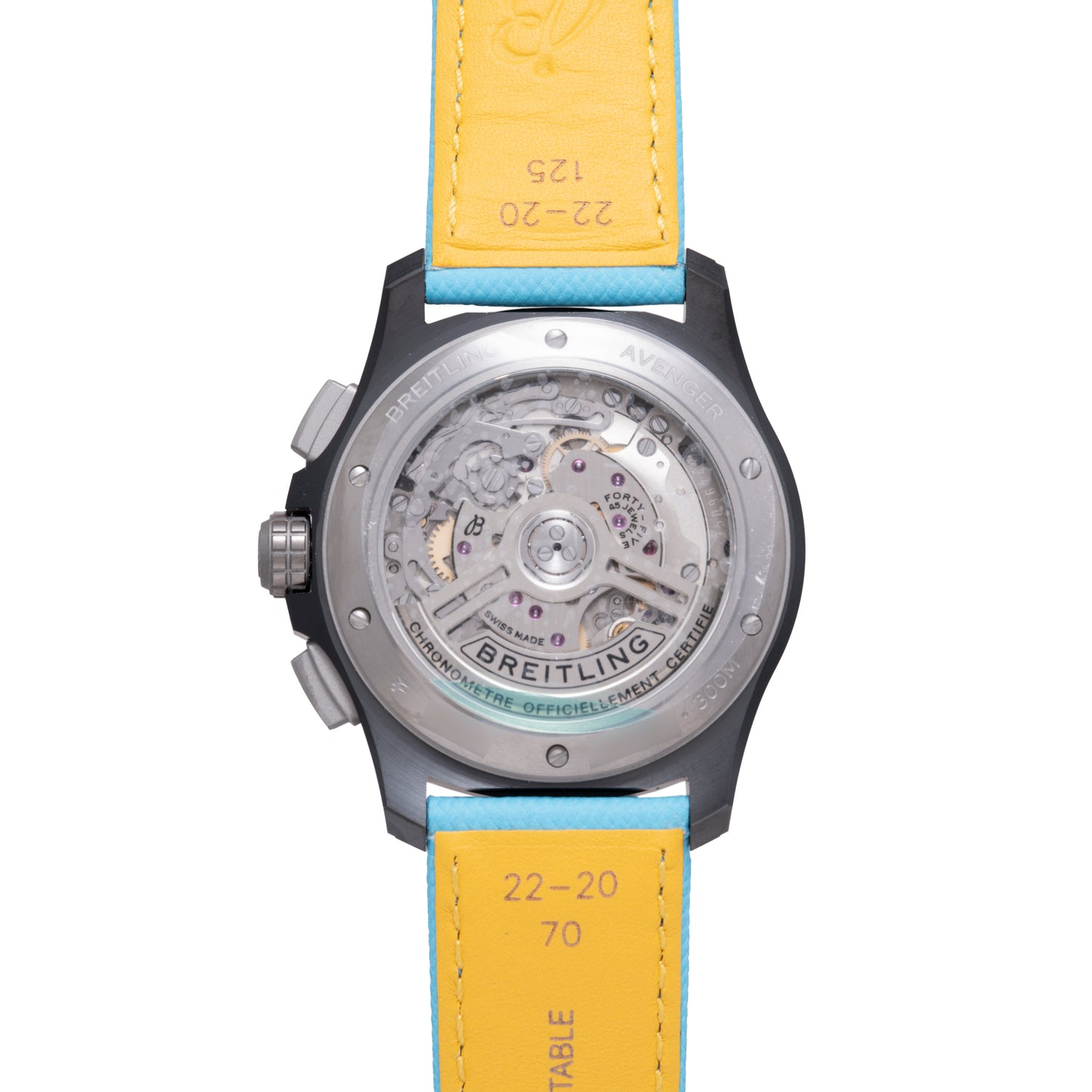 Back view of the Breitling Super Avenger B01 Chronograph 42, displaying its exposed mechanical movement through a transparent case and detailed engravings on the strap and metal case. Features a yellow and blue leather strap.