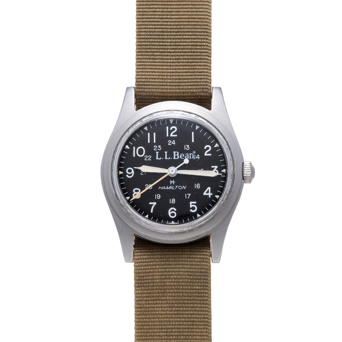 Hamilton Khaki Field mechanical watch with black dial, Arabic numerals, and tan fabric strap.