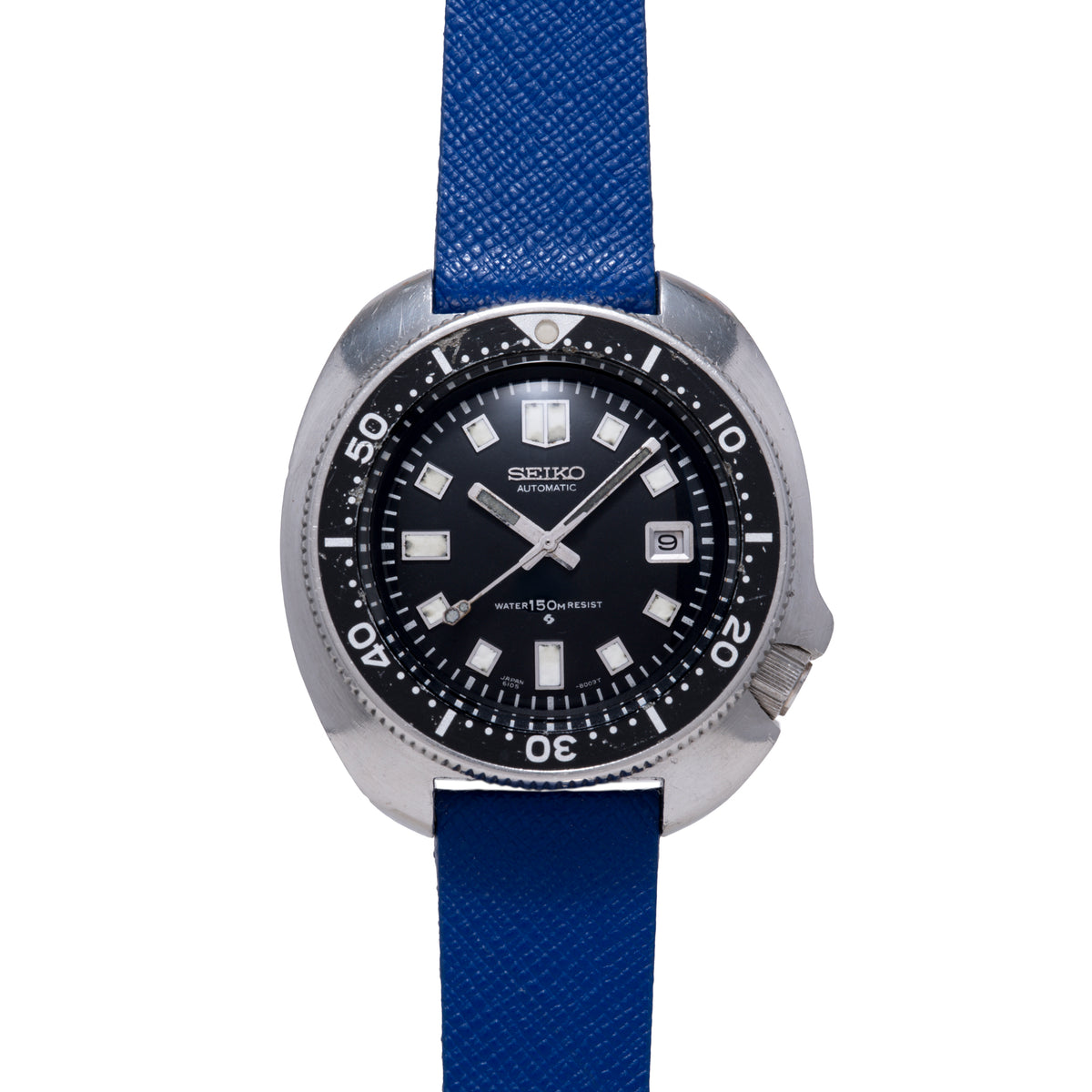 Seiko automatic diver watch with stainless steel case, black dial, rectangular hour markers, and blue fabric strap.
