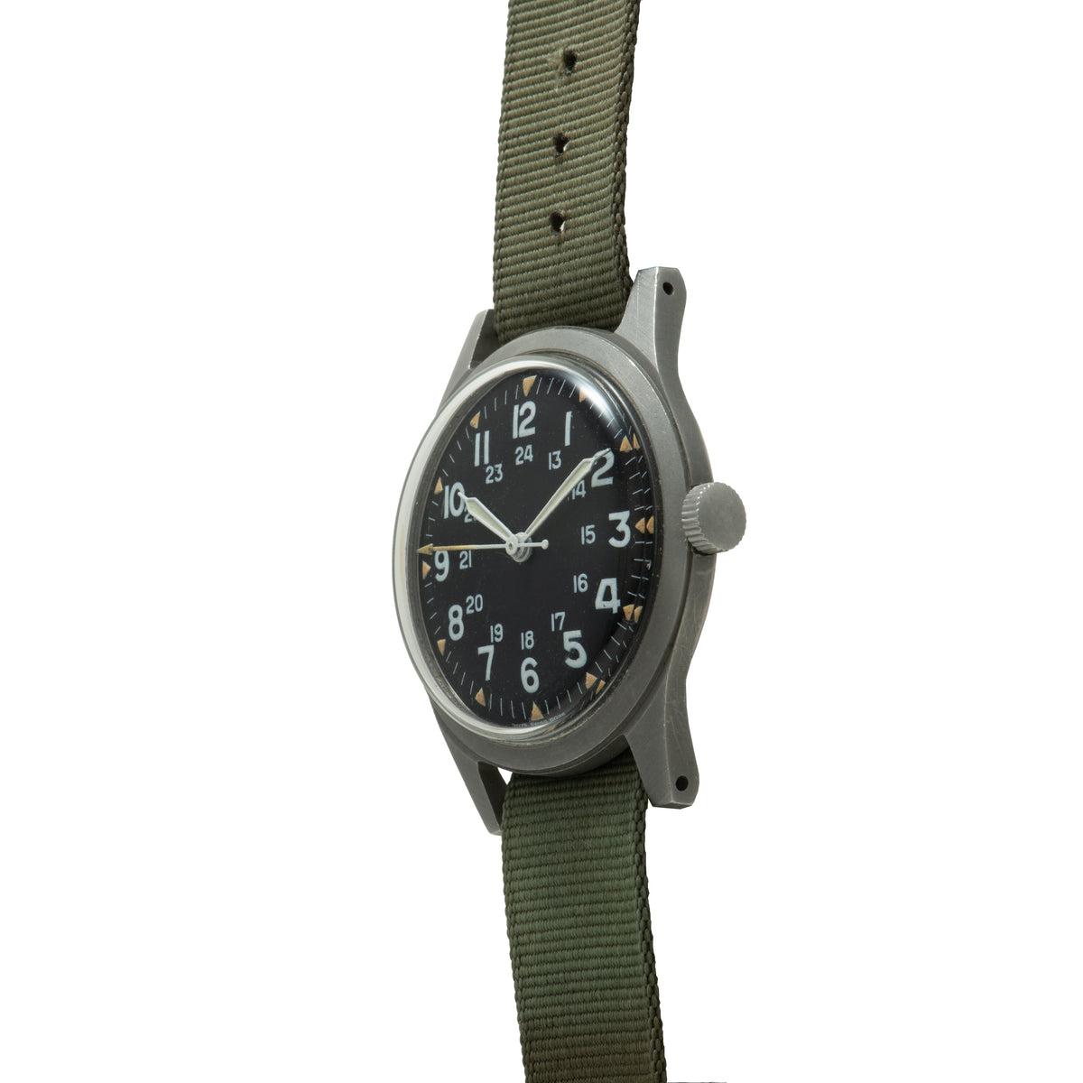 Stainless steel watch with black dial, white hands, numbered hour markers, and olive green fabric strap.