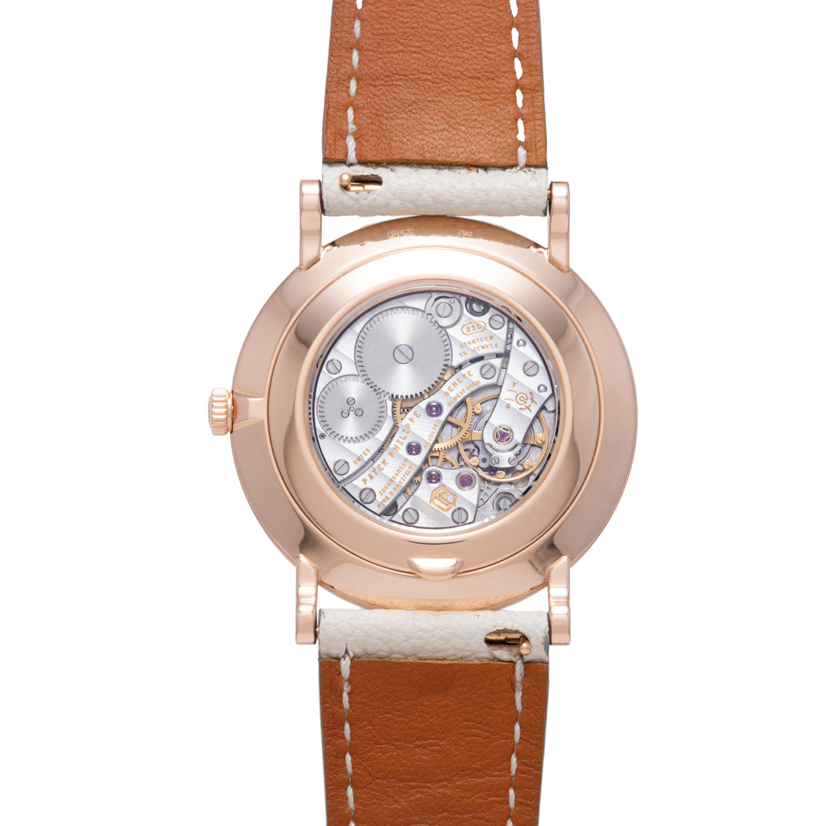 Rose gold watch with transparent caseback revealing mechanical movement, tan leather strap with white stitching.