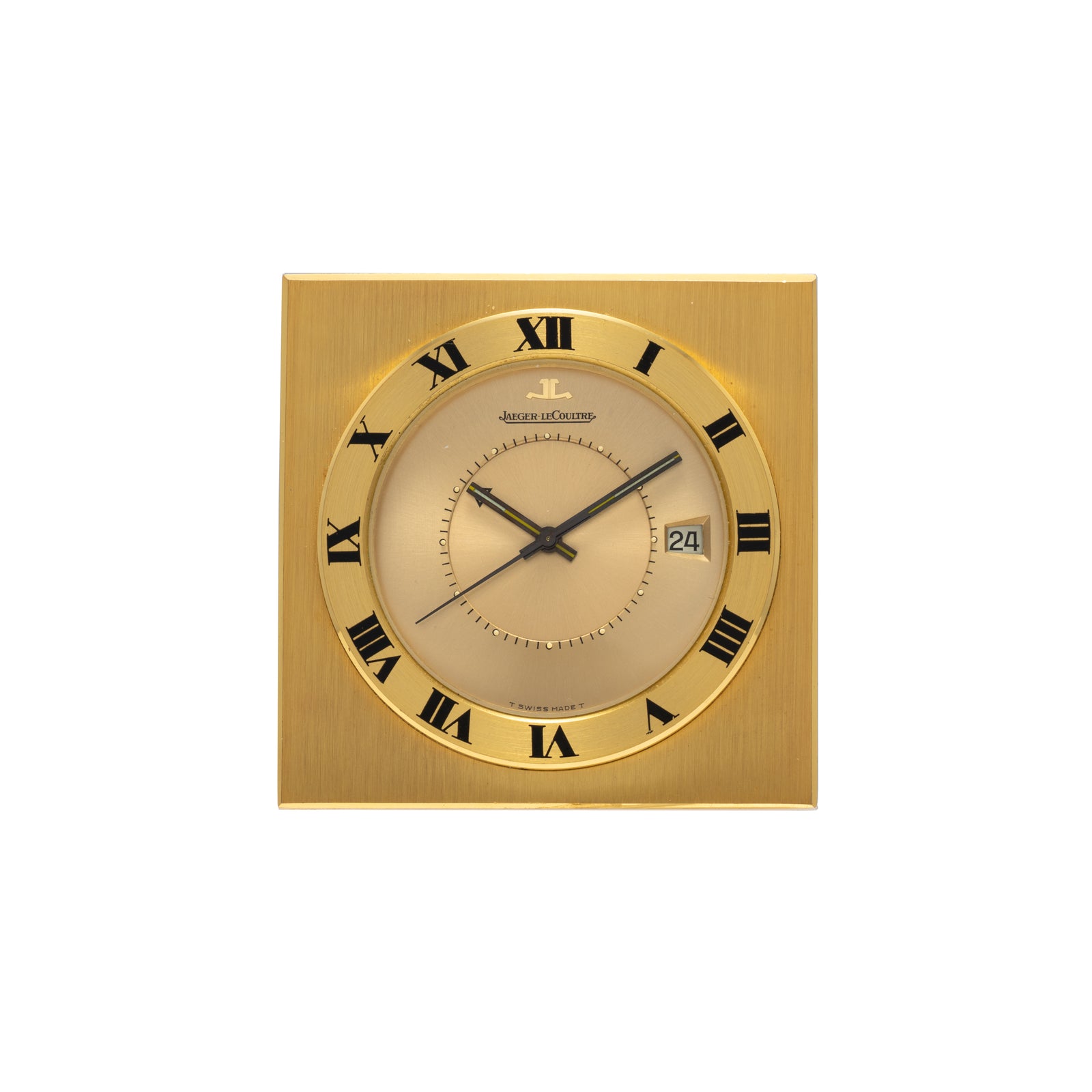 The Jaeger-LeCoultre Memovox Travel Calendar Alarm Clock features a square gilt-brass case, black Roman numerals and hands, a date display at 3 o'clock, and the Jaeger-LeCoultre logo at the top center in an elegant minimalist design.