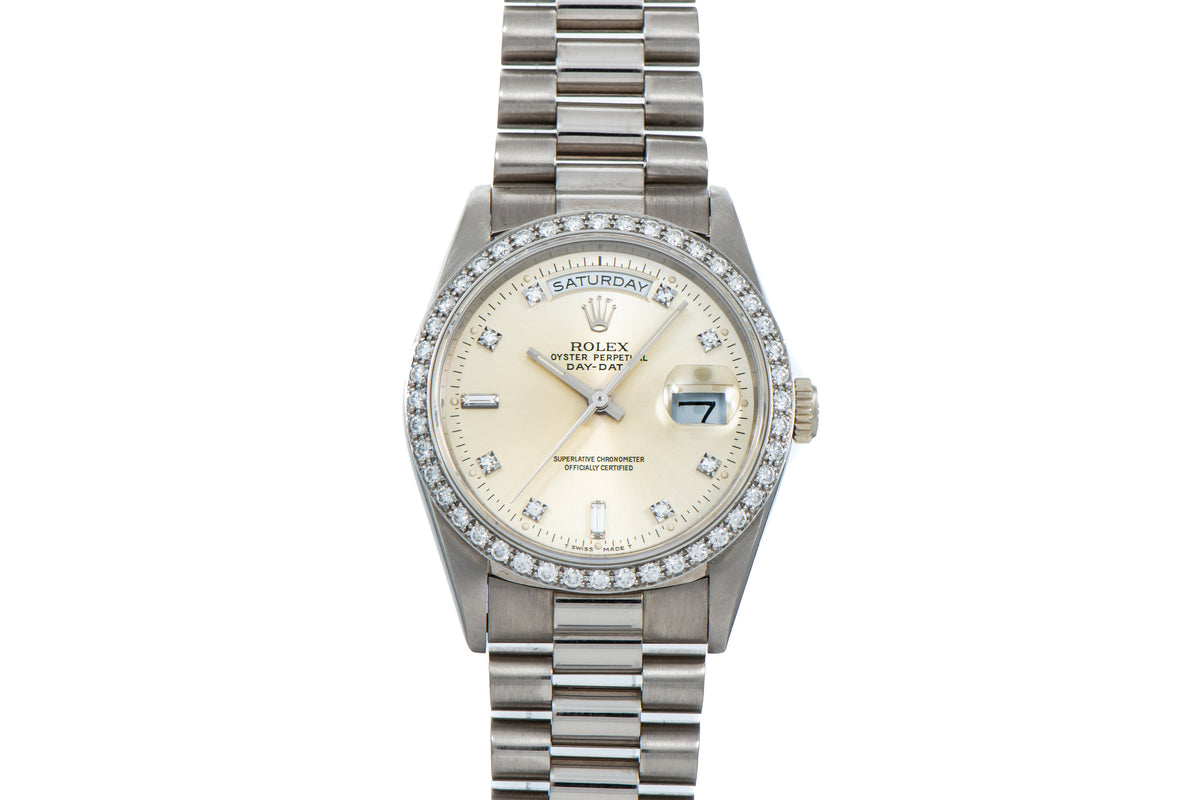 Rolex Day-Date watch with stainless steel bracelet, cream dial, diamond bezel, and day/date window.
