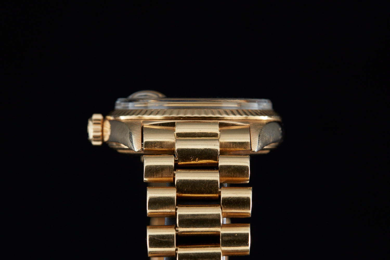 Solid gold vintage Rolex Datejust on black background lug view