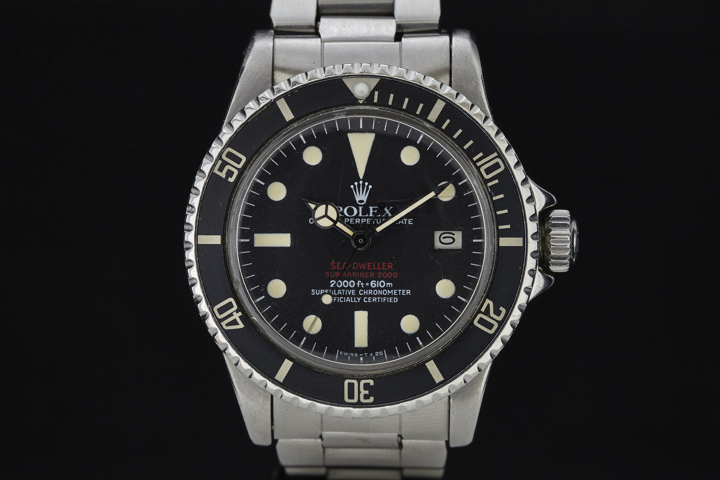 A close-up of a vintage Rolex Submariner wristwatch featuring a stainless steel band, black dial, luminous markers, and a date window at 3 o’clock. This iconic Rolex model is celebrated for its remarkable diving heritage.