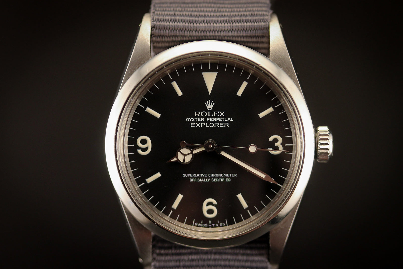Close-up of a Rolex Explorer 1016 - 1972 by Rolex, featuring a black dial, silver bezel, white hour markers, and gray fabric strap in vintage Submariner style, displaying the time as 10:09:37.