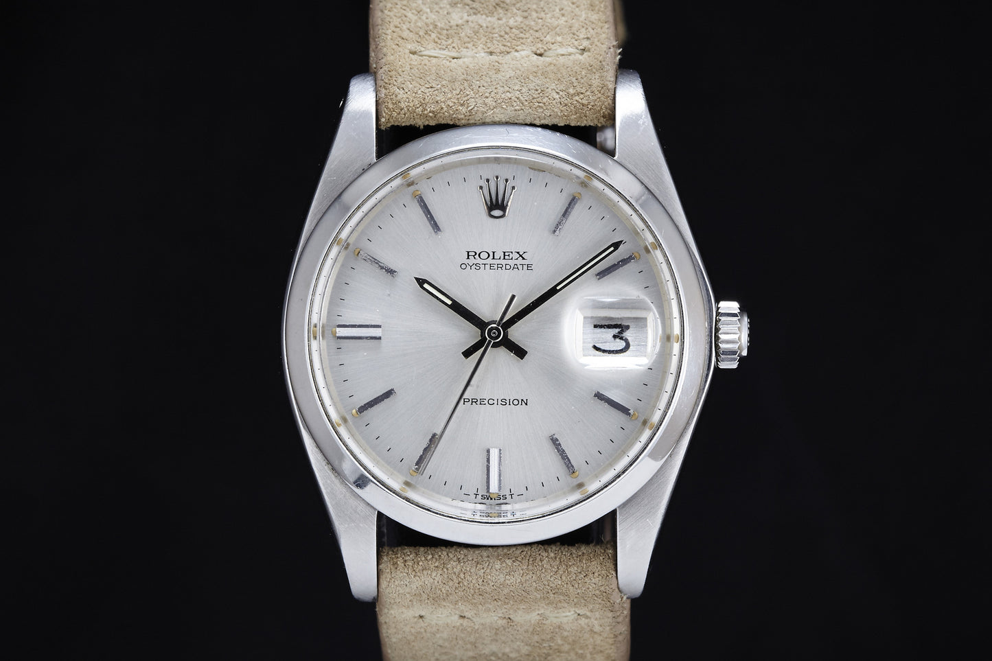 A close-up of the Rolex Oysterdate Precision - 1978 shows a silver case, beige leather strap, white dial with silver hour markers, and a date window at 3. The time reads about 10:10. Brand: Rolex.
