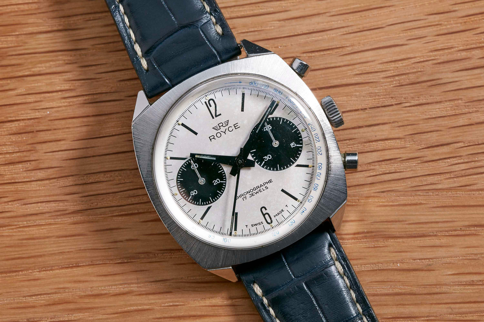 The Royce Panda Chronograph features a silver dial with two black subdials, a black leather strap, and a silver case—perfect for those seeking an affordable vintage chronograph from Royce.